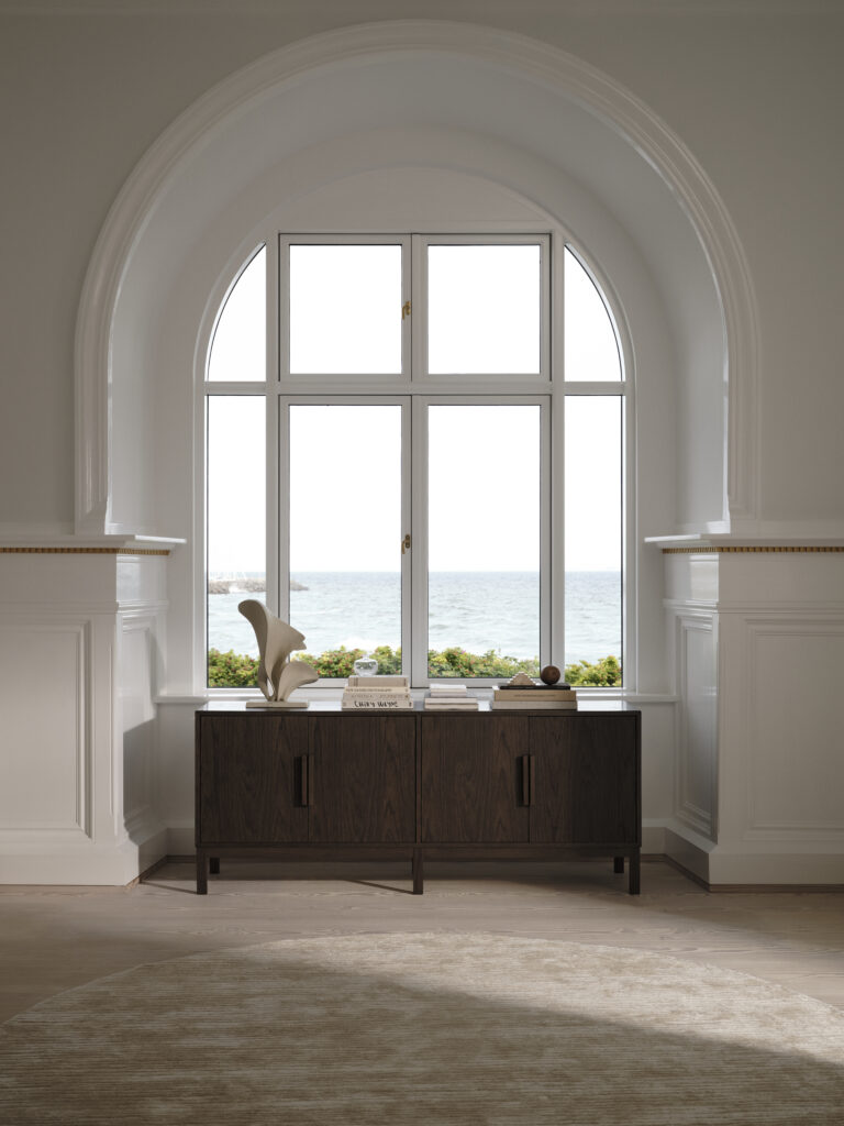 Komoda z kolekcji BoConcept AXO ustawiona z oknie z widokiem na wodę