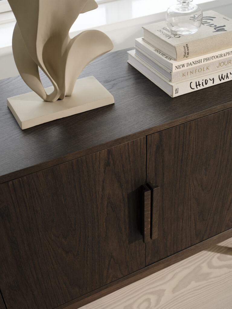 Komoda z kolekcji BoConcept AXO, obłożona książkami i ozdobami