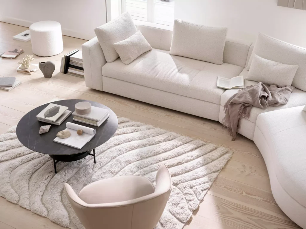 eżowa sofa skandynawska w jasnym salonie z drewnianą podłogą i minimalistycznymi dodatk