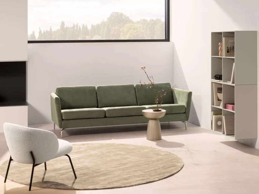 Zielona sofa skandynawska w nowoczesnym salonie z minimalistyczną aranżacją i jasnymi dodatkami