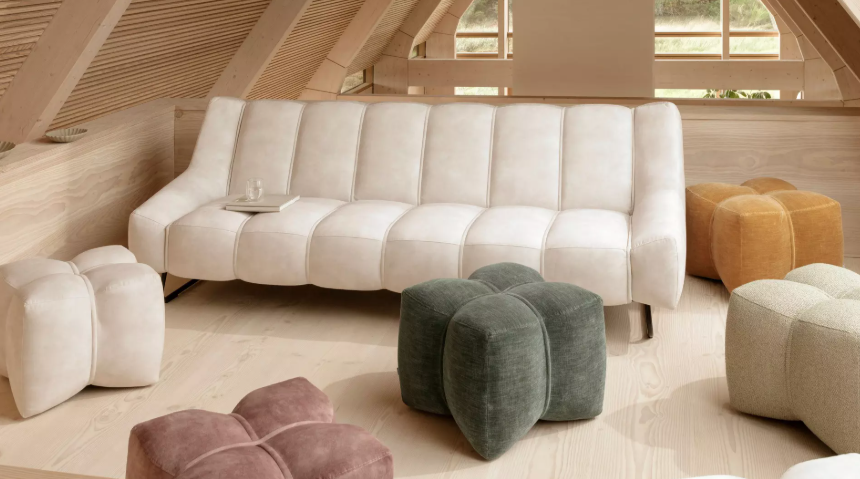 Jasna sofa premium w stylu skandynawskim z designerskimi pufami w nowoczesnym drewnianym wnętrzu
