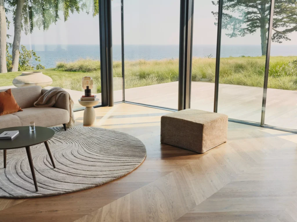Pufa Xtra BoConcept z funkcją spania w nowoczesnym salonie z widokiem na morze