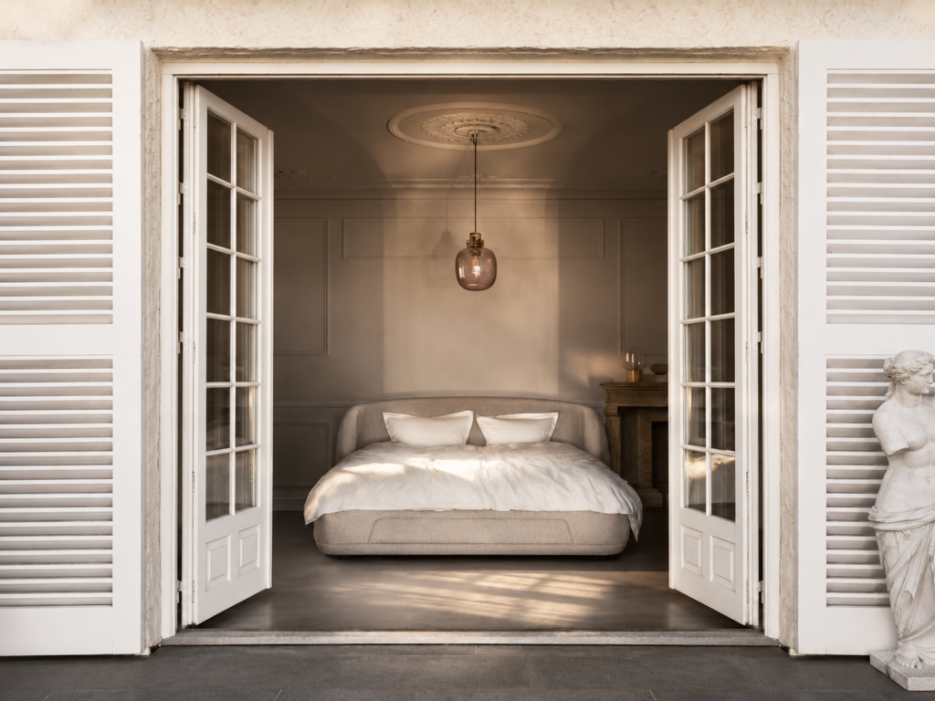 Łóżko Bolzano marki BoConcept widoczne przez otwarte drzwi tarasowe w eleganckiej sypialni inspirowanej duńskim designem.