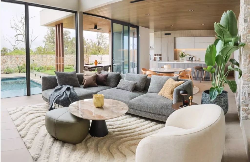 Salon BoConcept w realizacji Gledswood Hills z sofą Salamanca i widokiem na basen