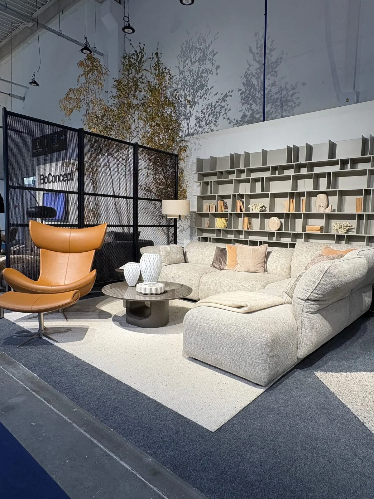 Ciemny stół BoConcept z krzesłami i lampą wiszącą na targach